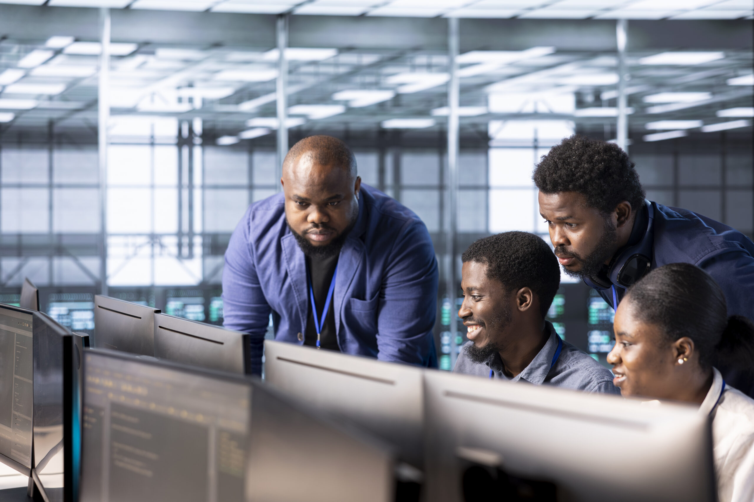 Team leader supervising IT workers in server room maintaining databases